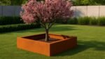 Ein rosa blühender Baum steht in einem quadratischen Pflanzkübel ohne Boden aus Cortenstahl Quadratisch 100cm x 100cm x H 30 cm Corten Frame 03 auf einem gepflegten Rasen mit grünen Sträuchern, hohen Gräsern und einem modernen hellgrauen Betonzaun dahinter.