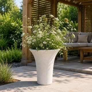 Weißer Pflanzkübel Romano aus Beton mit weißen Wildblumen vor einer sonnigen Holzpergola im Garten