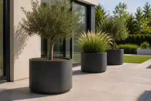 XXL runder Pflanzkübel aus Aluminium in Anthrazit auf moderner Terrasse mit Olivenbaum