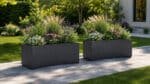 Pflanzkübel mit bunten Blumen und hohen Ziergräsern auf einem gepflasterten Gartenweg