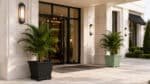 Pflanzkübel mit Palmen vor einem hellen, eleganten Hotelgebäude