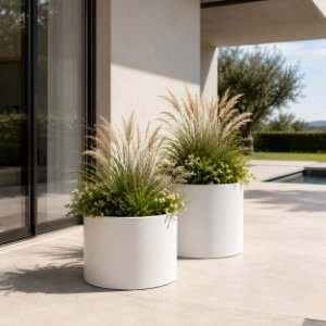 Pflanzkübel mit Ziergräsern und weißen Blüten auf einer modernen Terrasse