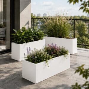 Pflanzkübel mit Ziergras, grünen Blattpflanzen und blühenden Pflanzen auf einem modernen Balkon
