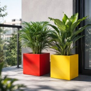 Pflanzkübel in Rot und Gelb mit üppigen grünen Pflanzen auf einem sonnigen Balkon