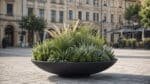 Schwarze Design-Pflanzschale MATTEO mit üppigen Ziergräsern und grünen Pflanzen auf einem historischen Stadtplatz